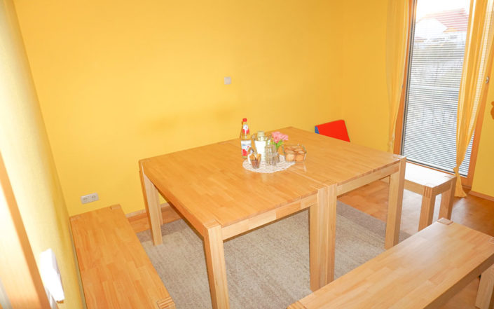 Esstisch in einem gelben Zimmer in der Hebammenpraxis in Neusitz